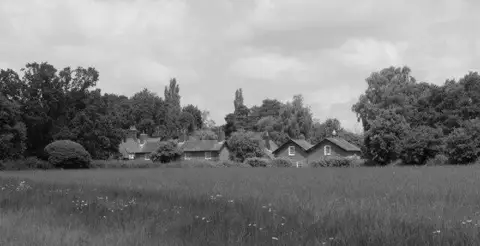 SJ8383 : Farmfold seen across a meadow, Quarry Bank, Styal